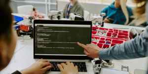 Angular developer sitting at a desk with a 2025 career roadmap, coding screen, and icons for HTML, TypeScript, RxJS, and frameworks