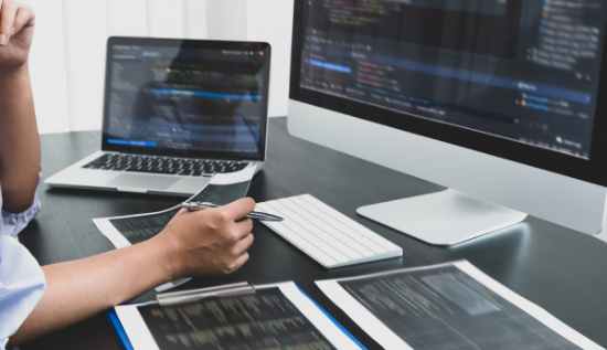 A person coding on a laptop, exploring free online web development courses.