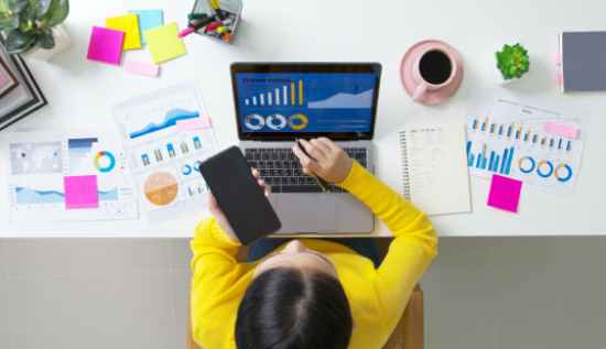 Remote data analyst job for freshers working from home on a laptop with charts and analytics.