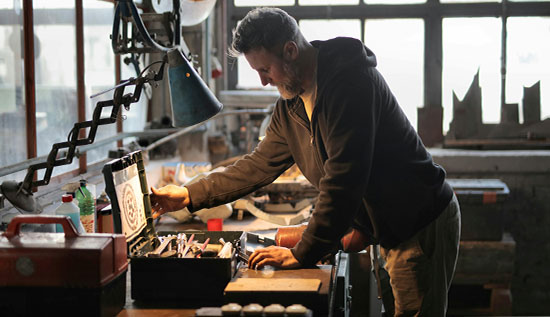 Robotics engineer working on a robotic arm in a high-tech lab, showcasing technical and programming skills essential for a career in robotics.