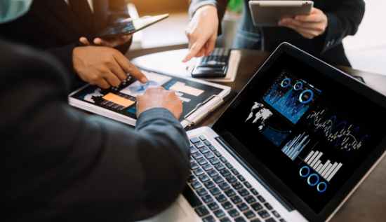 A business team analyzing data on digital screens, illustrating the impact of technology on modern enterprises.