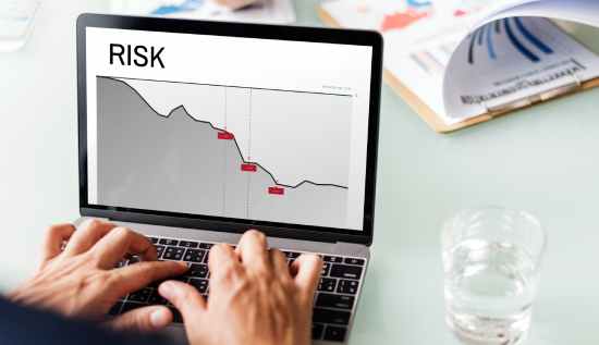 A diverse group of professionals analyzing risk management data on multiple screens in a modern office, representing the rising demand for risk management jobs in 2025.